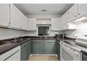 Functional kitchen with white appliances, white subway tile, and two-tone cabinets at 4631 Timbermill Ct # 203, Raleigh, NC 27612