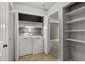 Laundry area with a washing machine, dryer, storage shelves, and tile flooring at 4631 Timbermill Ct # 203, Raleigh, NC 27612