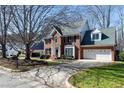 Traditional brick home boasting an attached two-car garage, beautiful lawn, and mature trees at 511 Windstream Way, Cary, NC 27518