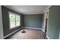 Bedroom with a window view, gray walls, white trim, and wood-look floors at 55 Livingston Ln, Spring Hope, NC 27882