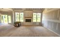 Bright living room featuring a fireplace with large windows providing scenic outdoor views at 55 Livingston Ln, Spring Hope, NC 27882