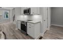 Eat-in kitchen featuring stainless appliances, white cabinets and stone countertops at 5601 Preston Pl, Raleigh, NC 27604
