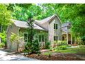 Two-story home with meticulous landscaping and a charming covered porch, all nestled in a serene, wooded environment at 574 Chatham Dr, Chapel Hill, NC 27516