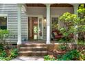 Inviting front porch with a cozy seating area, a wood ceiling, and a glimpse of the interior through the open door at 574 Chatham Dr, Chapel Hill, NC 27516