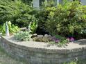 Charming garden with a small water feature surrounded by lush greenery and colorful flowers at 582 Wimbleton Dr, Raleigh, NC 27609