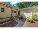 Inviting front entrance with brickwork, lush garden beds, and a freshly painted front door at 5822 Country Lane Dr, Durham, NC 27705