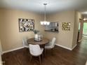 Cozy dining area with stylish lighting, modern art, and view to kitchen and living room at 600 Audobon Lake Dr # One B21, Durham, NC 27713