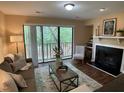Comfortable living room boasting a fireplace, plush seating, and balcony access with scenic views at 600 Audobon Lake Dr # One B21, Durham, NC 27713
