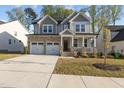 Charming two-story home with stone accents, a welcoming front porch, and a two-car garage at 604 Craftsman Ridge Trail Trl, Knightdale, NC 27545