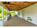 Covered porch featuring painted wood posts, a concrete floor, and a white door at 70 Fieldside Dr, Louisburg, NC 27549