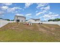 Spacious backyard with a white fence, an assortment of toys, and play equipment at 72 Ina Rose Ln, Four Oaks, NC 27524