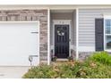 Close up of front door featuring a decorative wreath and lovely landscaping with flower bushes at 72 Ina Rose Ln, Four Oaks, NC 27524
