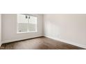 Neutral bedroom featuring hardwood floors and a window providing natural light at 79 Bronco Pace Dr, Clayton, NC 27520
