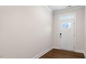 Bright entry foyer with a white door with glass panel and a transom window above, hardwood flooring at 79 Bronco Pace Dr, Clayton, NC 27520