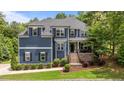 Inviting two-story home with landscaped front yard, brick-accented porch, and elegant curb appeal at 8304 Southmoor Hill Trl, Wake Forest, NC 27587