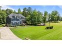 Expansive front lawn complements this two-story home, showcasing meticulous landscaping and natural beauty at 8304 Southmoor Hill Trl, Wake Forest, NC 27587