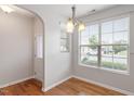 Bright dining area with hardwood floors, chandelier lighting, and large window at 9327 Falkwood Rd, Raleigh, NC 27617