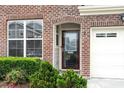 Up close look at the front door with brick surround and manicured landscaping at 9327 Falkwood Rd, Raleigh, NC 27617