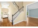Open entryway showcasing hardwood floors, staircase with black banister, and views into adjacent rooms at 100 Wentbridge Rd, Cary, NC 27519