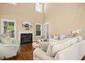 Bright living room with a fireplace, large windows, hardwood floors, and comfortable seating at 100 Wentbridge Rd, Cary, NC 27519