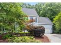 Side view of a charming home with lovely landscaping, healthy trees, and a paved driveway at 104 S Crabtree Knl, Chapel Hill, NC 27514
