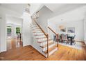 Bright foyer featuring hardwood floors, a staircase with wood handrail, and an adjacent dining room at 104 S Crabtree Knl, Chapel Hill, NC 27514