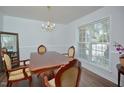 Formal dining room with hardwood floors, chandelier, and views of the greenery outside the window at 1056 Evening Shade Ave, Rolesville, NC 27571