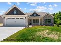 Charming single Gathering home with stone accents, siding, well manicured yard, and a two car garage at 109 Drew St, Louisburg, NC 27549