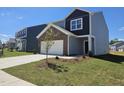 Well-manicured two-story home with attached two-car garage and freshly landscaped front yard at 109 Gabriel Ct, Wilson's Mills, NC 27520