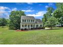 Charming two-story home boasts a welcoming front porch, manicured lawn, and lush landscaping, creating an inviting curb appeal at 113 Feezor Ct, Clayton, NC 27527