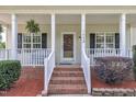 Inviting front porch with brick steps, white railings, and a decorative hanging plant near the front door at 113 Feezor Ct, Clayton, NC 27527