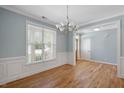 Elegant dining room featuring wood floors, classic wainscoting, and a stylish chandelier at 120 Tanager Farms Dr, Youngsville, NC 27596