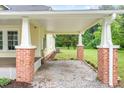 Attached carport with brick pillars and white trim, offering sheltered parking and side yard access at 1398 Tarboro Rd, Youngsville, NC 27596