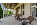 Inviting covered front porch with wicker furniture and stained wood ceiling at 1412 Wakefield Farm Rd, Zebulon, NC 27597