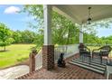 Relaxing front porch offers brick flooring, classic columns, and views of the landscape at 14393 Nc Hwy 96 N, Zebulon, NC 27597