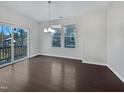 Bright living room with hardwood floors, a large window, and sliding glass doors to a balcony at 1466 Salem Creek Dr, Apex, NC 27502