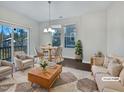 Staged living room with a hardwood floor, natural light, comfortable seating, and a view of the outdoors at 1466 Salem Creek Dr, Apex, NC 27502