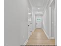 Bright hallway featuring light walls, wood flooring and white doors at 154 Buckaroo Dr, Louisburg, NC 27549