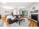 Open-concept living room with a fireplace, hardwood floors, and access to outdoor seating, perfect for entertaining at 16 Tottenham Ln # 16, Chapel Hill, NC 27517