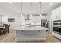 Modern kitchen with stainless steel appliances, a central island, and sleek white cabinets at 1612 Commons Ford Pl, Apex, NC 27539