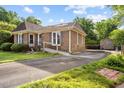 Side view of brick home featuring a ramp, driveway, and storage shed at 1641 Regency Dr, Burlington, NC 27215