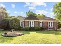 Charming brick home with mature landscaping, a birdbath, and a well-manicured lawn creating an inviting curb appeal at 1641 Regency Dr, Burlington, NC 27215