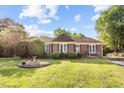 Charming brick home with mature landscaping, a birdbath, and a well-manicured lawn creating an inviting curb appeal at 1641 Regency Dr, Burlington, NC 27215