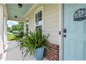 Cozy porch view features a light-blue door, brick accents, and potted plants at 18 Heathgreen Dr, Clayton, NC 27527