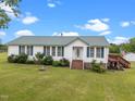 Inviting single-story home with a well-manicured lawn, white siding, and accents of green at 1993 Lucy Garrett Rd, Roxboro, NC 27574