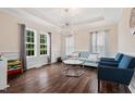 Bright living room with hardwood floors, a tray ceiling and a decorative chandelier at 200 Vintage Hill Cir, Apex, NC 27539
