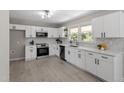 Modern white kitchen featuring sleek appliances, ample cabinets, a bright window, and stylish countertops at 2003 Broadway Rd, Sanford, NC 27332