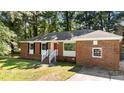 All brick house featuring a bright red front door and well manicured lawn at 208 Essex Rd, Nashville, NC 27856