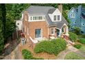 Charming brick home, showing side entrance, mature landscaping, and well-kept lawn at 2236 The Cir, Raleigh, NC 27608