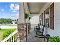 Cozy front porch features rocking chairs, stone columns, and space for relaxing outdoors at 230 Paddy Ln, Youngsville, NC 27596